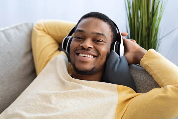 Nahaufnahme eines entspannten Schwarzen, der mit Headset Musik hört — Stockfoto