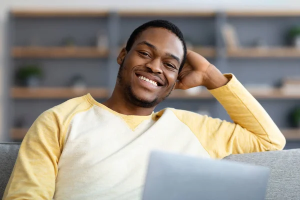 Primer plano del chico negro con el ordenador portátil sonriendo a la cámara —  Fotos de Stock