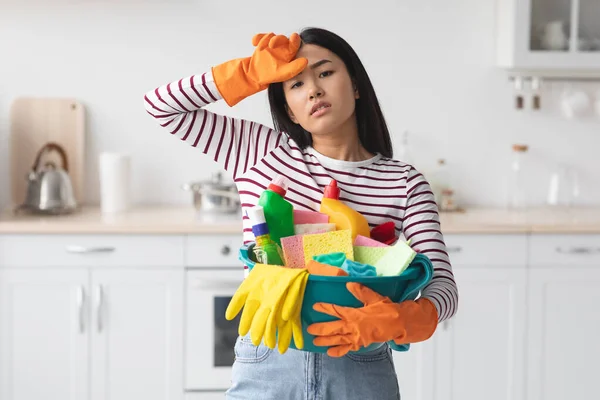 Hard-working asian woman with busket full of cleaning supplies — Stock Photo, Image