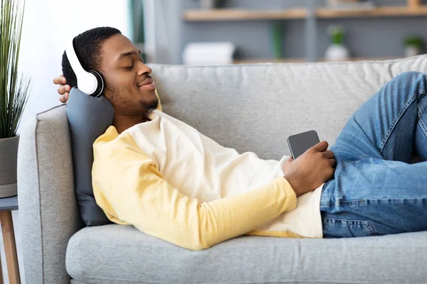 携帯電話で音楽を聴くリラックスしたアフリカ系アメリカ人男性 — ストック写真