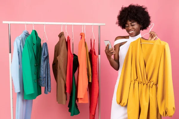 Neşeli Siyah Kadın Alışveriş Telefon Tutma Elbisesi, Pembe Arkaplan — Stok fotoğraf