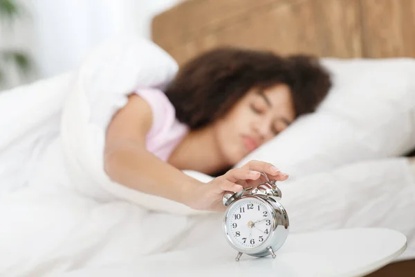 De dame schakelt de wekker uit en wordt 's morgens wakker van de oproep. — Stockfoto