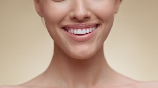 Blanqueamiento dental. Primer plano de la joven dama irreconocible ampliamente sonriendo a la cámara, mostrando su sonrisa perfecta — Vídeo de stock