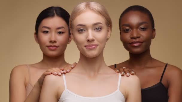 Three happy ladies smiling to camera, asian and african american women touching shoulder of their caucasian friend — Stock Video