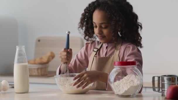 Adorabile bambina afroamericana che prende un pezzo di pasta cruda e lo mangia, prepara la pasticceria in cucina e sorride. — Video Stock