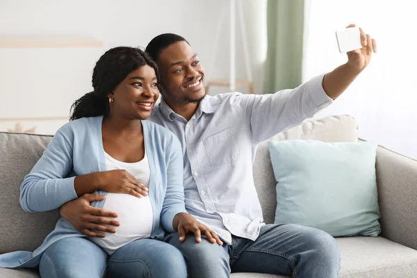Pozitivní těhotné černošky rodina užívat selfie, pomocí smartphonu — Stock fotografie