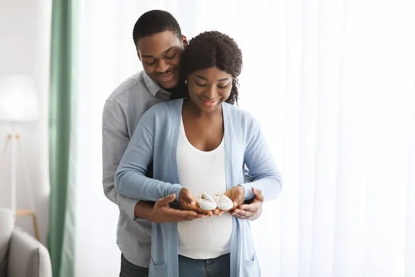 Счастливая беременная африканская американская семья держит маленькие детские попки — стоковое фото