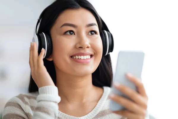 Portrait de femme asiatique heureuse dans les écouteurs sans fil bénéficiant de la musique sur Smartphone — Photo