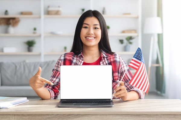 Study English Online. Asian Woman With American Flag Pointing At Blank Laptop — Stock Photo, Image