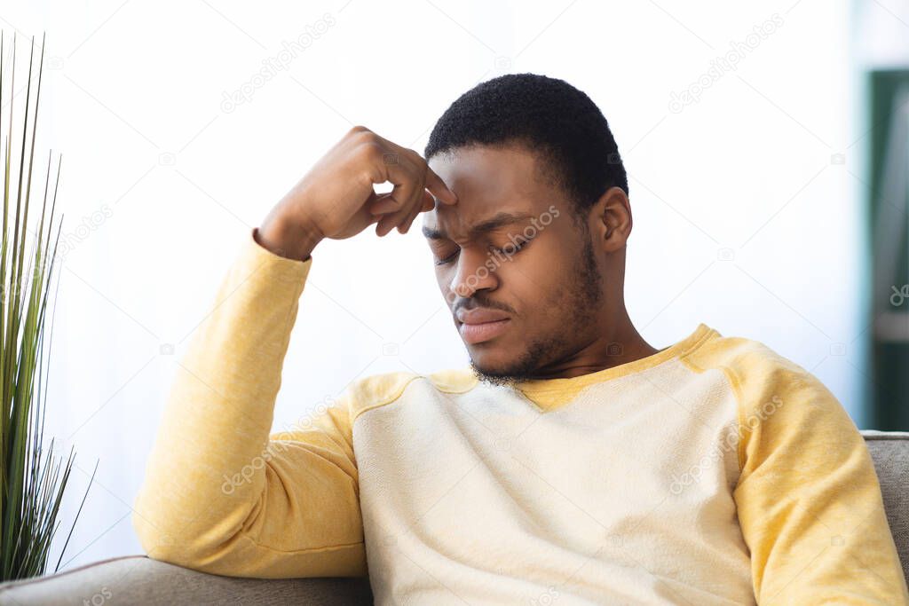 Upset black guy suffering from headache, closeup