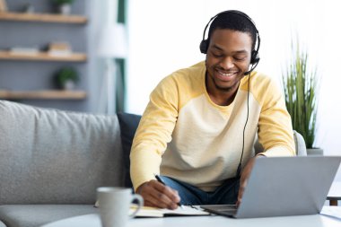 Evdeki çevrimiçi eğitime katılan pozitif siyahi adam.