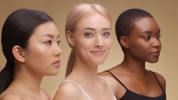 Ung lykkelig hvit dame som smiler til kamera, poserer med asiatiske og afroamerikanske venner, halvprofilert portrett – stockvideo