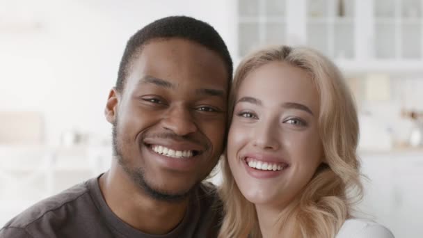 Feliz pareja multiracial sonriendo a la cámara posando en interiores — Vídeos de Stock