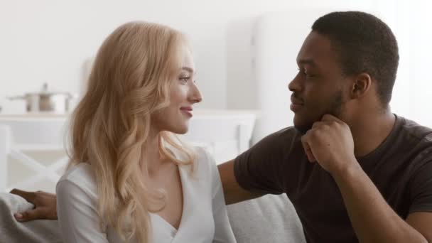 Amar al esposo negro tocando la barbilla de las esposas coqueteando sentado en casa — Vídeo de stock