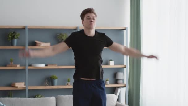 Ausdauertraining. Junger athletischer Mann macht Jumping Jack Übung, übt Training zu Hause, Zeitlupe — Stockvideo
