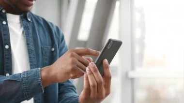 Havalimanında duran akıllı telefonu kullanan Afrikalı Amerikalı turist.