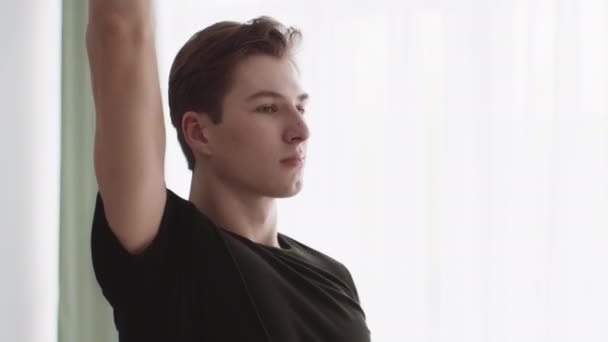 Närbild porträtt av ung aktiv kille öva värma upp motion hemma, träna med händerna, slow motion — Stockvideo