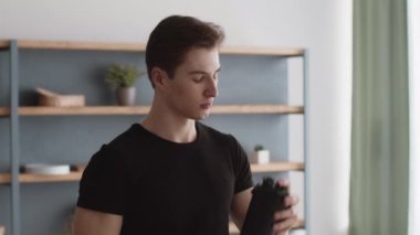 Kilo alma diyeti. Genç kaslı sporcu, protein kokteylini karıştırıyor ve evde içiyor, kapat.