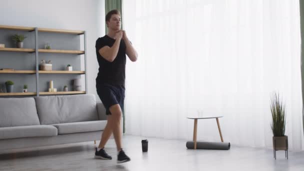 Starka rumpor träning. Ung tusenårig idrottsman tränar lungor framåt motion, utbildning hemma interiör — Stockvideo