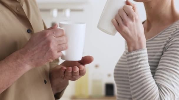 Onherkenbaar paar Drinken Koffie Holding Cups Poseren Staande in de keuken — Stockvideo