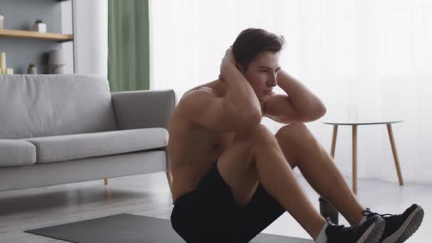 Abs προπόνηση στο σπίτι. Αθλητικός μυώδης άνδρας που κάνει κοιλιακούς στο πάτωμα, γυμνάζεται με γυμνό κορμό και μόνο — Αρχείο Βίντεο