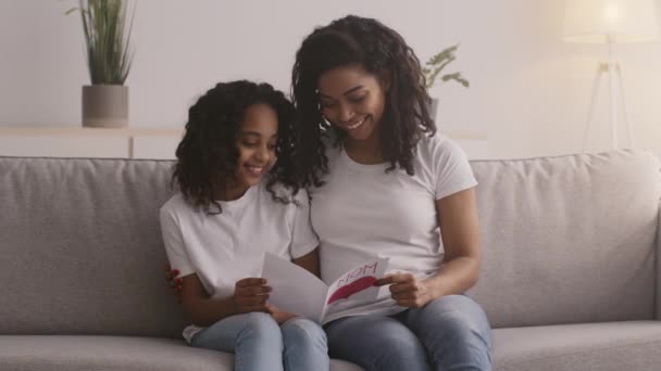 Dia das mães. Feliz amor afro-americano mãe e filha ligação, sorrindo com cartão de saudação artesanal — Vídeo de Stock