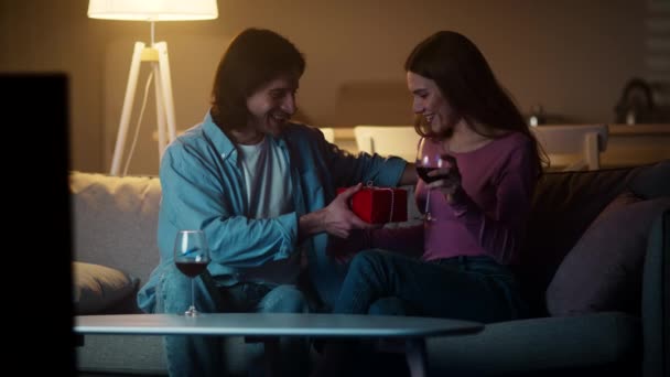 Homem feliz no amor dando caixa de presente para sua namorada, mulher satisfeita abraçando seu namorado, desfrutando de noite romântica — Vídeo de Stock