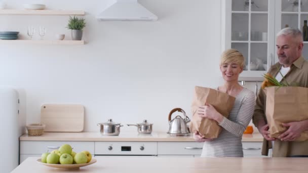 Eşler Mutfağa giriyor Bakkal poşetlerini taşıyor ve açıyor — Stok video