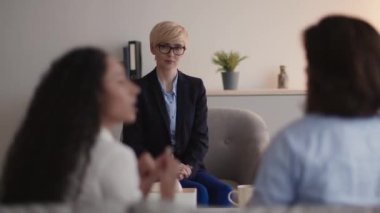 Duygusal evli çift psikologla tartışıyor. Profesyonel danışman onlara bakıyor.