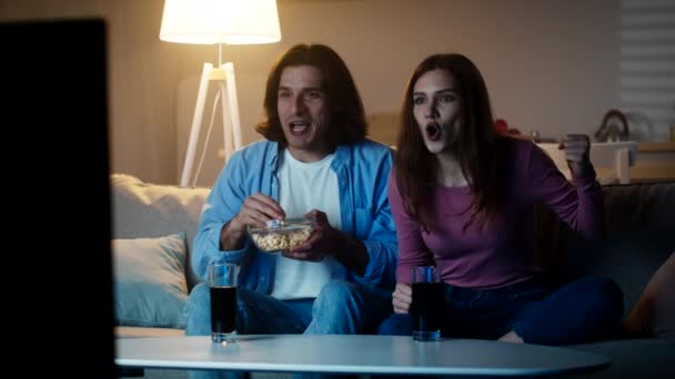 Familia de aficionados al fútbol. Emocional hombre y mujer viendo deporte juego juntos, animando a su equipo favorito y disfrutando de la meta — Vídeo de stock