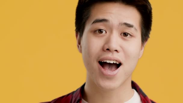 Joyeux chinois jeune homme gestuelle OK signe sur fond jaune — Video