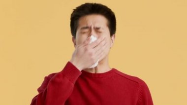 Hasta Asyalı Adam Turuncu Arkaplan Üzerine Kağıt Peçeteye Hapşırıyor