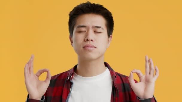 Pacífico japonés chico meditando haciendo om gesto sobre amarillo fondo — Vídeos de Stock