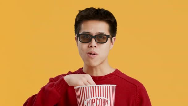 Alegre asiático hombre usando gafas 3D viendo película, fondo amarillo — Vídeo de stock