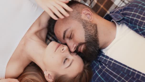 Top vista retrato de feliz amado homem e mulher descansando sobre cobertor, acariciando uns aos outros, desfrutando de conexão — Vídeo de Stock