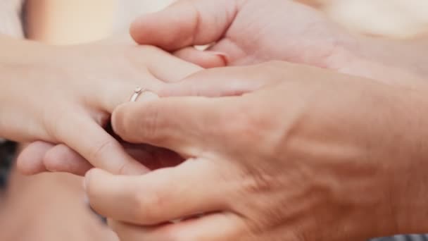 Engagement concept. Close up shot of man putting diamond ring on female finger and stroking her — Stock Video