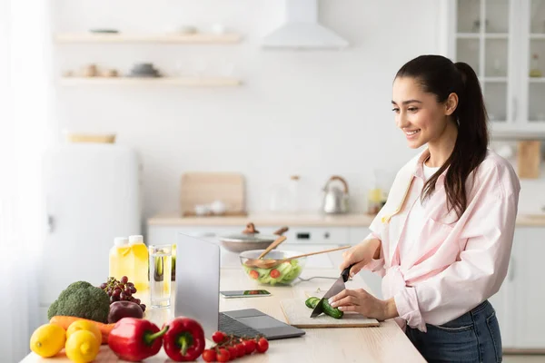 Frau kocht Salat und benutzt PC und Küche — Stockfoto