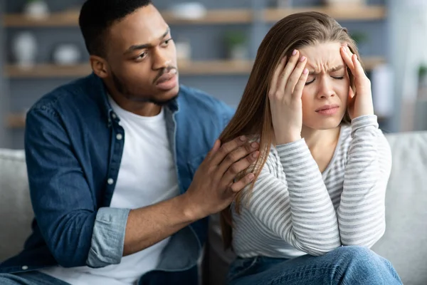 Loving zwarte man troosten zijn verontwaardigde witte vriendin thuis — Stockfoto