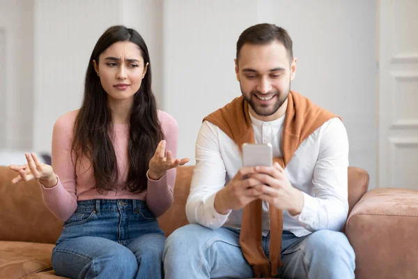 ( 영어 ) Puzzled Middle-Eastern Woman Looking at Husband Texting On Smartphone Indoor — 스톡 사진