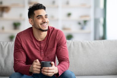 Kanepede oturan, çay içen, fotokopi çeken neşeli Arap adam.