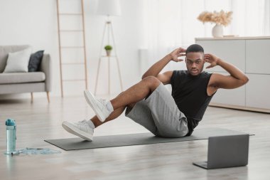 Diz dirseğe, karın çatırdatma ameliyatı yapan Afrikalı Amerikalı adam.