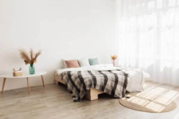 Intérieur confortable et style minimaliste. Lit double avec oreillers et couvertures, tables avec plantes sèches dans des vases — Photo