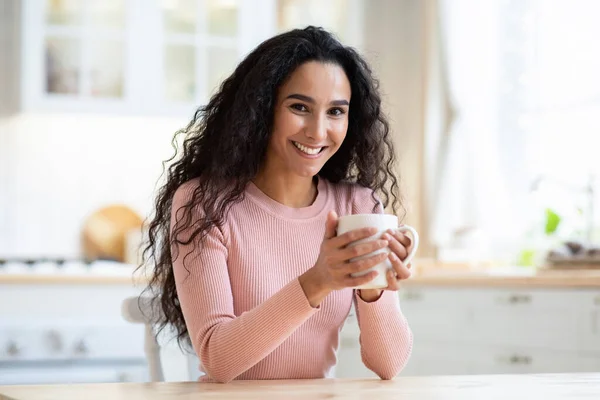 Morgenkaffee vorhanden. Porträt einer lächelnden schönen jungen Frau mit einem Becher in der Hand — Stockfoto