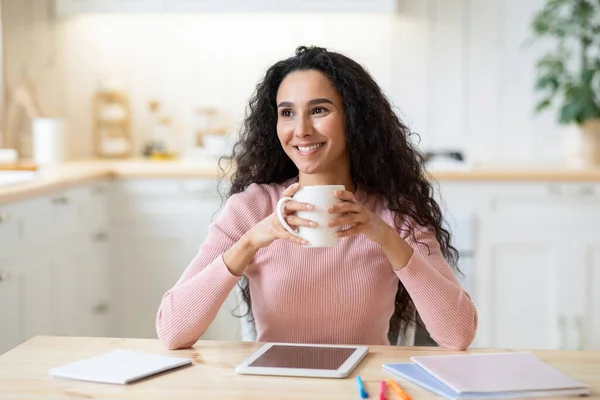 Portret van glimlachende Brunette Freelancer Lady genietend van een kopje koffie in de keuken — Stockfoto
