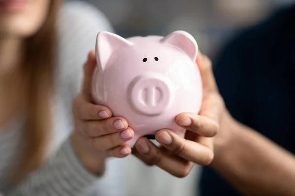 Casal irreconhecível segurando Pink Piggybank em mãos, economizando dinheiro para o futuro — Fotografia de Stock