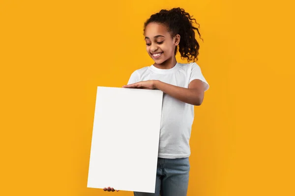 Zwart meisje houden blanco wit reclame billboard in studio — Stockfoto