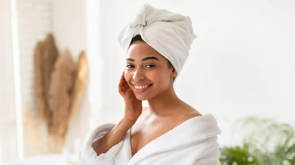 Happy Black Lady toucher le visage avec une peau lisse dans la salle de bain — Photo