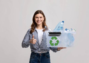 Atık ayıklama. Gülümseyen Genç Kadın Plastik Şişeleri Geri Dönüşüm İçin Taşıyor