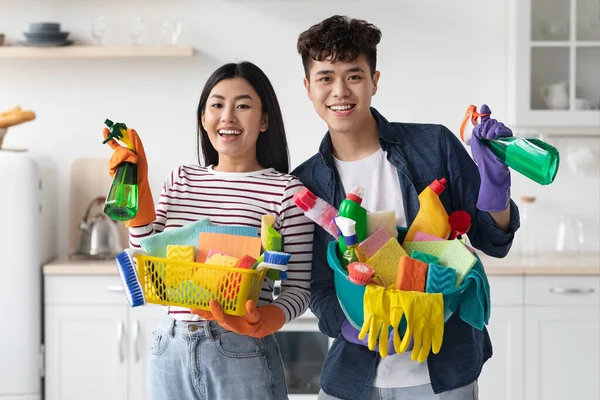Θετικός νεαρός Κορεάτης άνδρας και γυναίκα με προμήθειες καθαρισμού — Φωτογραφία Αρχείου