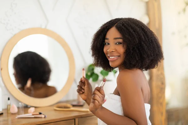 Joyeux jeune femme noire appliquant rouge à lèvres devant le miroir à la maison, espace de copie — Photo